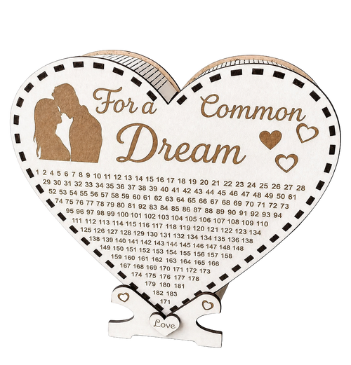 Heart-shaped wooden savings box with “For a Common Dream” engraving, couple silhouette, heart details, love tag, and a numbered savings tracker.