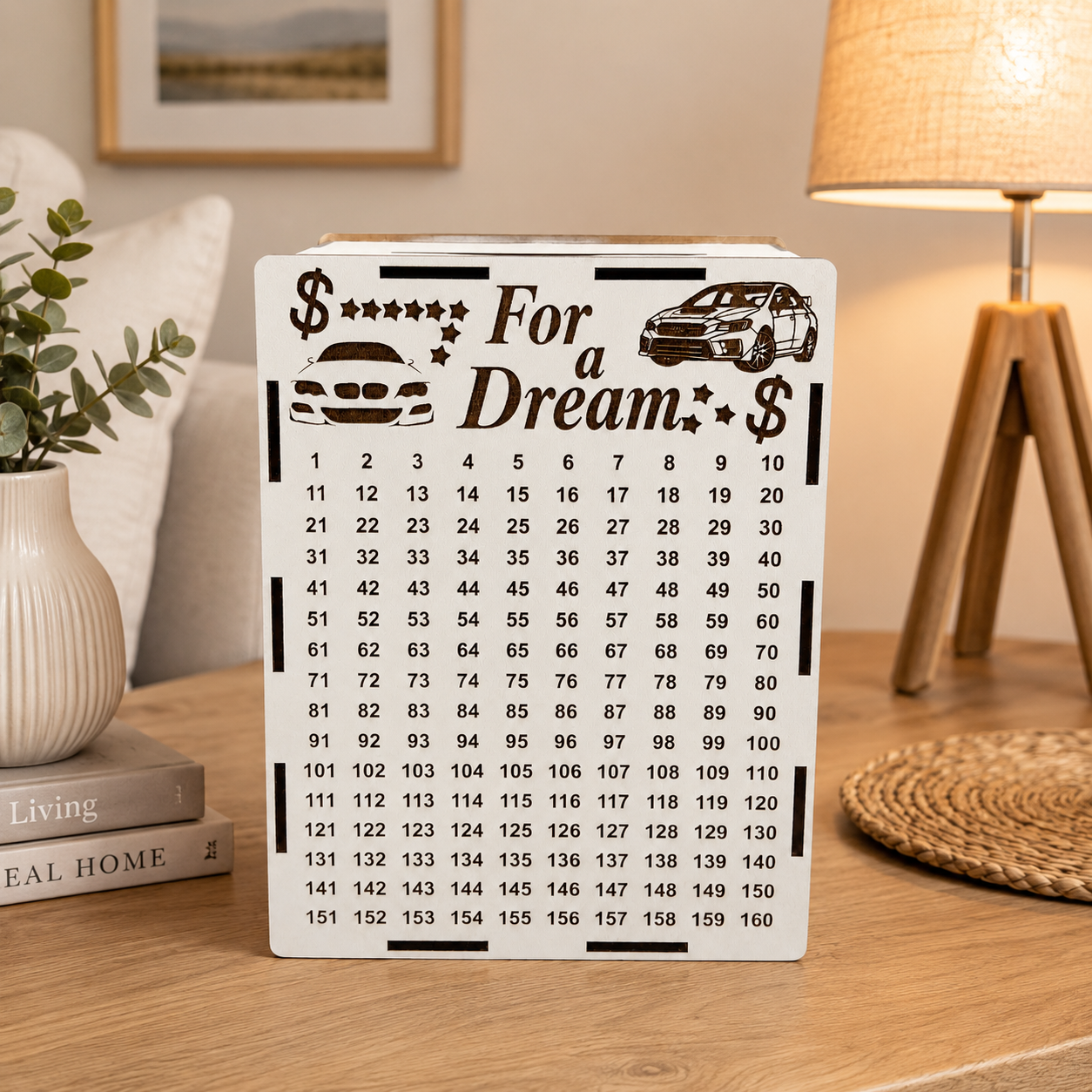 White wooden “For a Dream” car savings piggy bank standing on a wooden table in a cozy home interior with warm lighting and neutral decor.