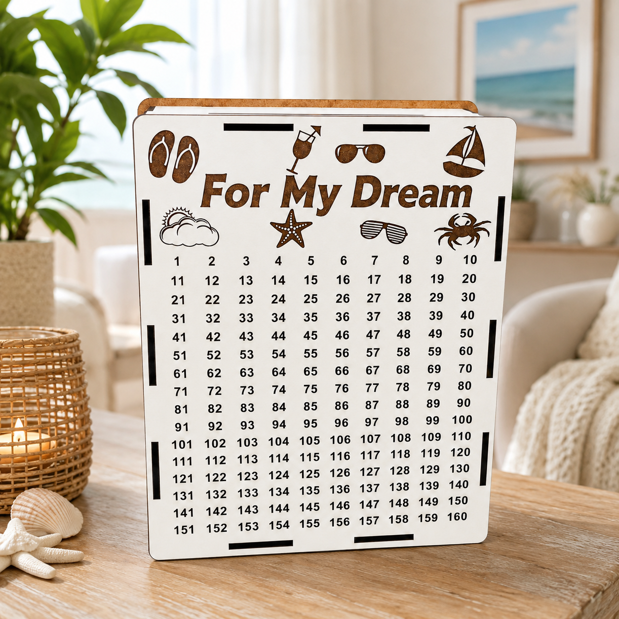 White wooden “For My Dream” vacation savings piggy bank standing on a wooden table in a bright coastal-style room with plants, seashells, soft decor, and natural light.